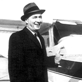 Black and white photo of smiling man wearing a hat